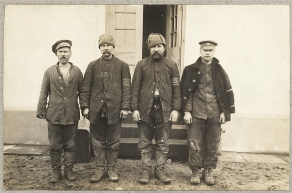 Fire russiske krigsfanger foran hus i Brørup