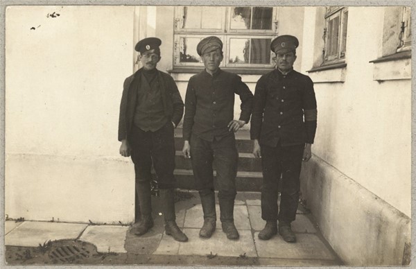 Tre russiske krigsfanger foran hus i Brørup