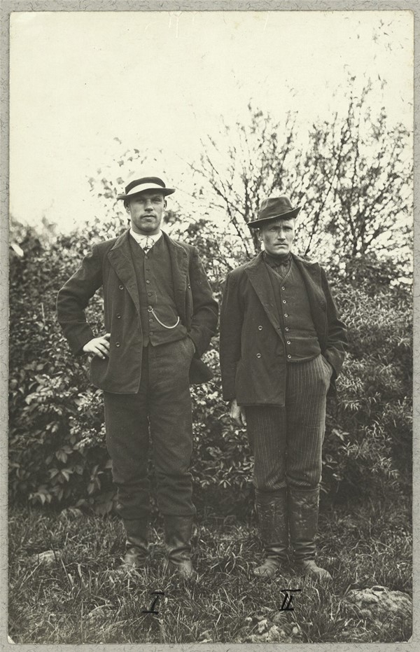 To russiske krigsfanger foran busk