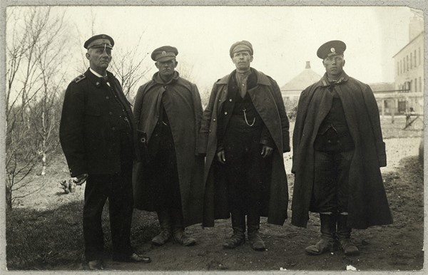 Tre russiske krigsfanger og dansk embedsmand foran hus i Ribe