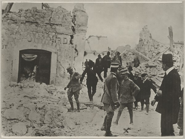 Soldater og lokalbefolkning i sønderbombet by